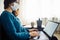 Businesswoman stays home and works during coronavirus epidemia quarantine. Female worker wearing a medical mask and typing on a