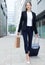 Businesswoman in suit with suitcase is going to the hotel