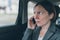 Businesswoman talking on mobile phone on car back seat