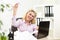 Businesswoman throwing paper airplane in office