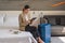 Businesswoman traveller sitting on bed using computer tablet in hotel room