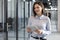 Businesswoman uses digital tablet standing in the office corridor