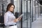 Businesswoman uses digital tablet standing in the office corridor