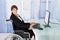 Businesswoman using computer while sitting on wheelchair