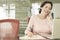 Businesswoman Using Mobile Phone While Writing On Notepad