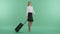 A businesswoman walks with baggage and looks at the timetable