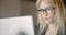 Businesswoman Wearing Eyeglasses While Using Laptop In Office