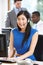 Businesswoman Wearing Headset Working In Busy Office