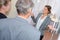 Businesswoman welcoming couple to office