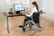 Businesswoman On Wheelchair Analyzing Graph