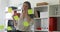 Businesswoman in white blouse considering sticky notes on glass and talking on phone.