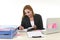 Businesswoman working at laptop computer office desk taking notes writing on notebook