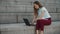 Businesswoman working on laptop outside. Executive typing on laptop at street