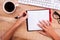 Businesswoman writing on diary on desk