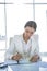 Businesswoman writing on diary on desk