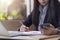 Businesswoman writing something idea in note on calendar and using smartphone with computer laptop, Working and Agenda planning