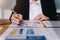 Businesswomen analyzing data financial reports on wooden table