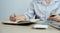 Businesswomen bookkeeper hands writing to notebook and count dollar note and doing account for paying tax on white desk in working