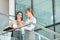 Businesswomen gossiping while having coffee on steps in office