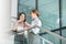 Businesswomen gossiping while having coffee on steps in office