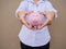 Businesswomen hand holding pink piggy bank on brown cement wall background, Saving money for future plan and retirement fund