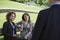 Businesswomen On Park Bench Looks At Businessman