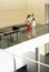 Businesswomen Reading Diary Together By Glass Railing In Office