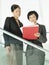 Businesswomen Reviewing Documents On Stairs