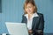 Businesswomen use laptop to find information on working with vintage blue backdrops in coffee shop