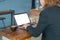 Businesswomen use laptop to find information on working with vintage blue backdrops in coffee shop