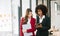 Businesswomen work and discuss their business plans. A Human employee explains and shows her colleague the results paper in modern