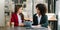 Businesswomen work and discuss their business plans. A Human employee explains and shows her colleague the results paper in modern