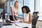 Businesswomen Working At Office Desk On Computer Together