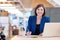 Busineswoman smiling broadly while working in her office cubicle