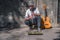 A busker street musician playing music with clarinet on a city sidewalk