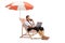 Bussinesman sitting on a deck chair under umbrella and using a laptop computer and a smartphone