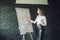 Bussiness, meeting and education - businesswoman with flipchart in office