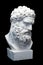 Bust of the Farnese Hercules. Heracles head sculpture, plaster copy of a marble statue isolated on black. Son of Zeus