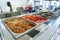 Bustling Cafeteria Serving Line During Lunchtime Offering a Variety of Dishes