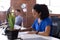 Busy african american businesswoman sitting at desk with hygiene screen writing in office