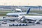 Busy airfield view with airplanes and service vehicles. View of International Airport with planes, gangways, trucks and service