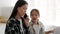 Busy Asian Freelancer Mom Ignoring Daughter Talking On Cellphone Indoor