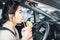 Busy Asian woman eating fast food and drink coffee in car