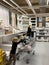 Busy atmosphere inside IKEA furniture store with customers choosing the right shelves young girl pushing cart