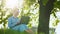 Busy attractive woman working at the laptop as sitting on grass in city park