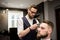 Busy barber shaving customer hair