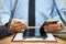 Busy businessman in office at the desk using two mobile phones,