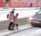 Busy city people on zebra crossing in motion blur. Winter snowy day