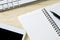 Busy desk of a businessman with an open diary and tablet.