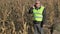 Busy farmer with smartphone on cold corn field